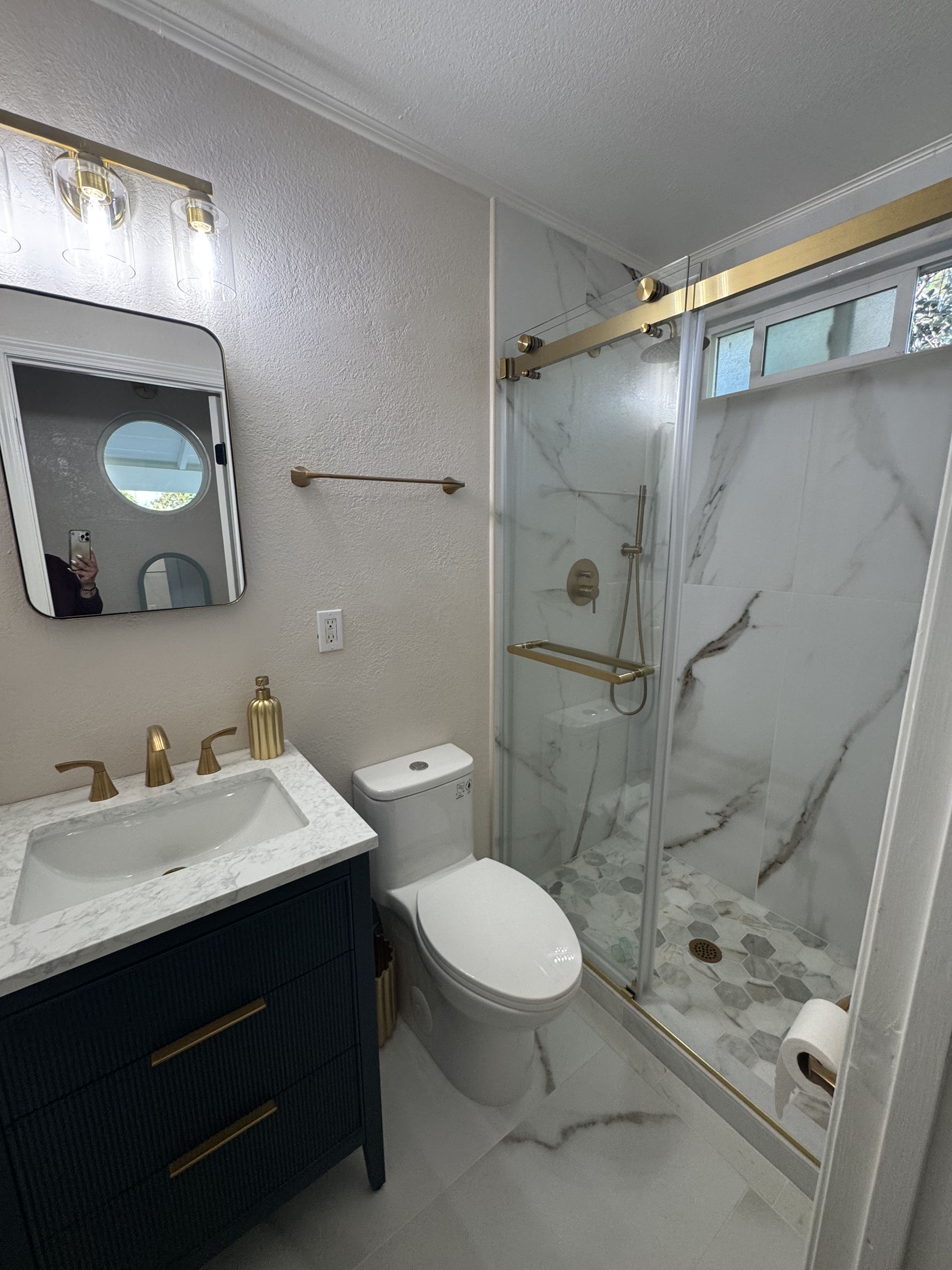 Primary suite en suite bathroom with marble shower and brass fixtures